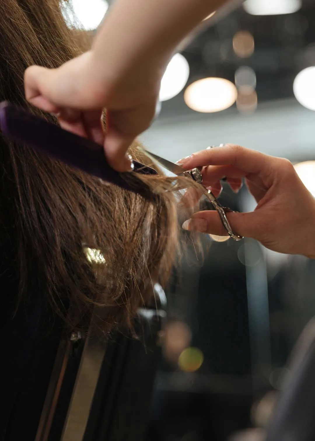 A professional stylist cuts a woman's brunette locks at inside a hair salon. Studio 101 Salon is one of the top hair salons in Morgantown WV. When you're searching for hair salons near me, look no further than one of the best hair salons in Morgantown WV.